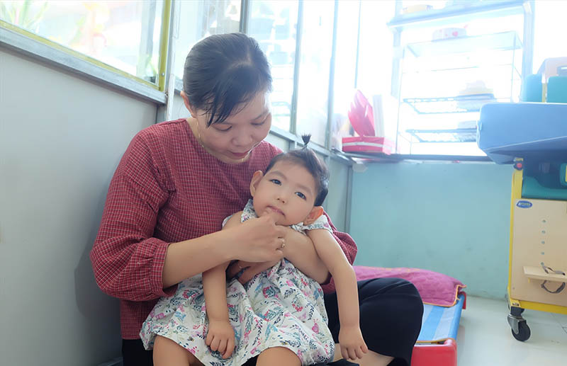 Chị Thủy dành trọn tình yêu thương chăm sóc cô con gái nhỏ. Ảnh: baoquangnam.vn