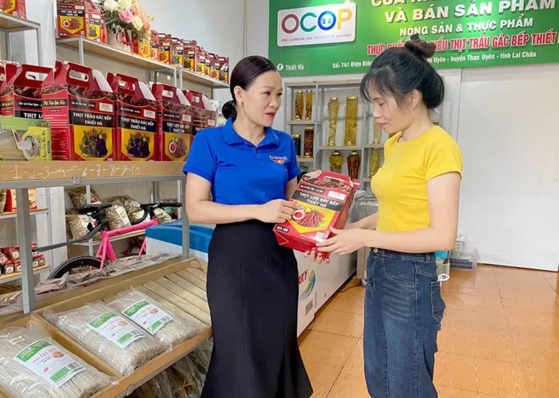 Chị Lê Thị Hà (bên trái) giới thiệu sản phẩm của hợp tác xã cho khách hàng